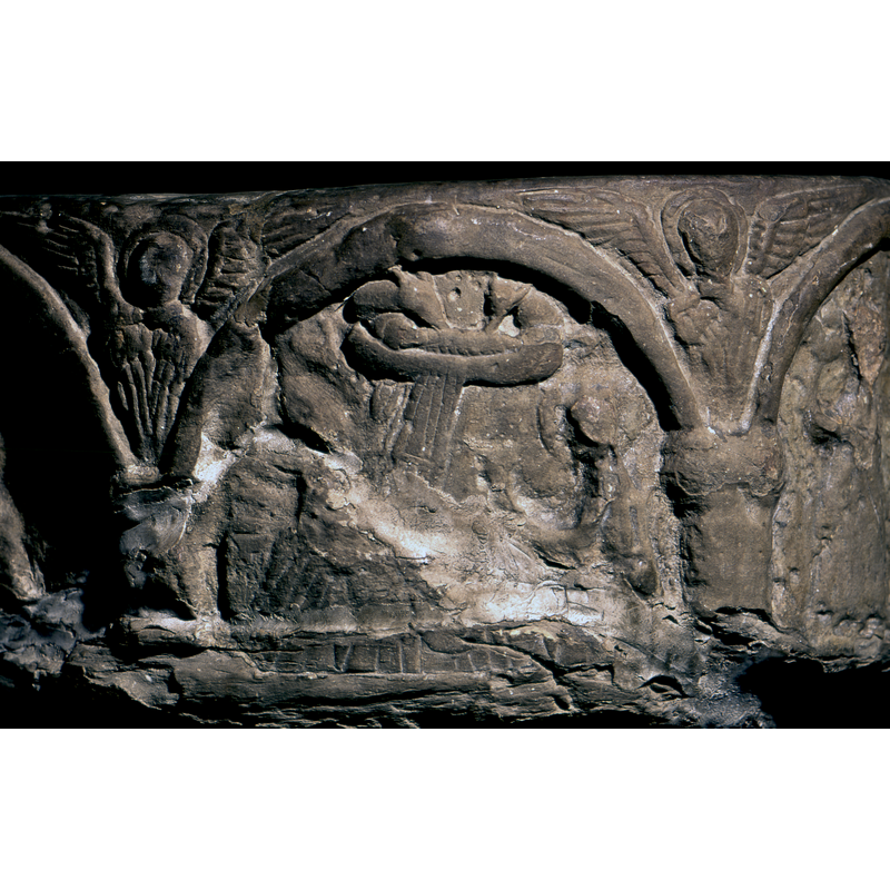 this side of the basin is badly damaged, and much detailed has been lost -- Mary is not evident herself, but part of the long covers of the bed have survived; only a silhoute of Joseph remains, seated (?) on the right of the image; haloed; his arm (?) appears to stretch towards the bed; at the top, right beneath the top of the arch-head, is a cradle/manger with a swaddled child, head to he left; a band of rays falls from the cradle towards the Virgin; above the cradle not much is left of the ass and ox