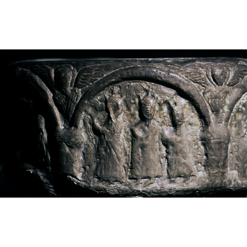 Three figures crowned, in profile, walking toward the Nativity scene; there is no Madonna and Child in this scene; their arms are held up holding gifts; the upper part, right beneath the arch-head, appears to have traces of an angel or of star with rays of light