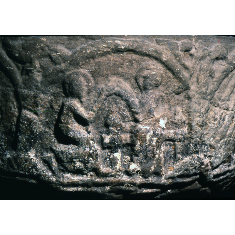 Adoration of the Magi takes place over two arches. In the first are the two magi, walking from left to right, in profile, haloed, bearing gifts. The first, to the far left, has his hands covered with a cloth. In the second arch, the last maji, kneeling right hand raised toward the virgin. Holds a gift. The Virgin sitting on altar like bench, right hand close to the magi and holds child which has been broken off (was sitting to the far right side of her).