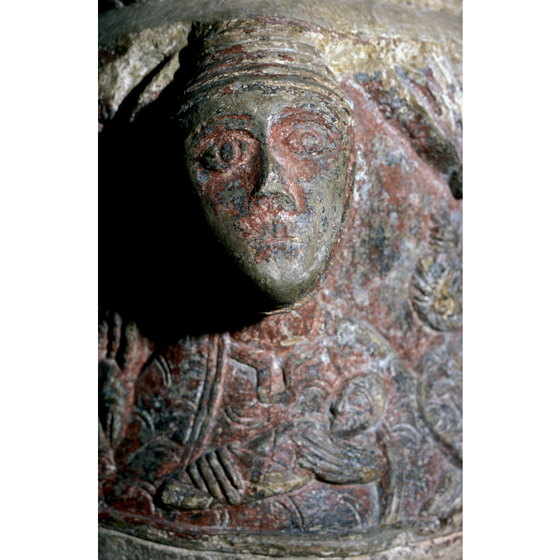 Head of a Woman, bust of a woman wearing a conical hat, her body on base, holds a swaddled child to her chest - madonna and child? -- the head is part of the set of four at 90-degree angles, but the body, including the babe-jn-arms,is a low-relief carving on the main block of the base