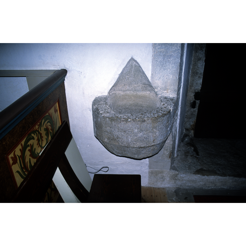 a wall-mounted stoup by the entranceway