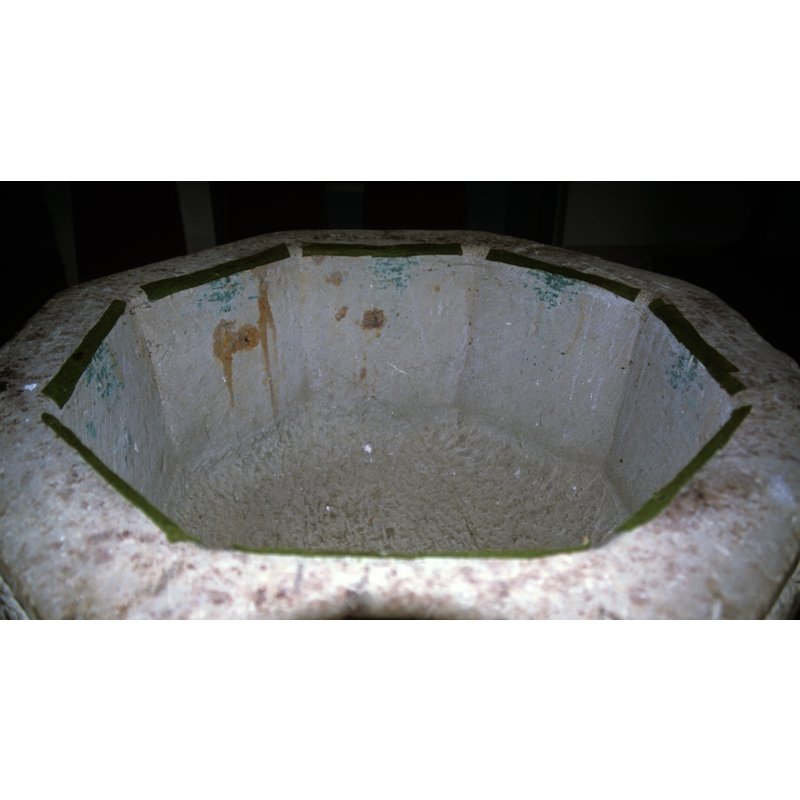 the green felt strips, put in place to cushion the metal baptismal dish, are leaking colouring into the stone