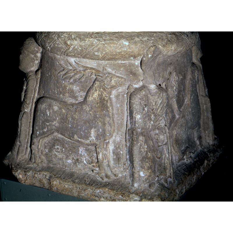 Bishop seated with hand in benediction and holding a book is seen here on the left