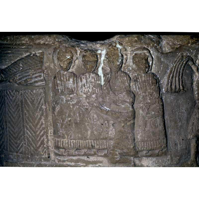 Last Supper - in the forefront - is a figure kneeling, hands parallel to ground, behind him is a table with objects on it. Att the table, four figures, all haloed, full frontal, the third from the left appears to be Christ. With his right hand he feeds the figure in the foreground.