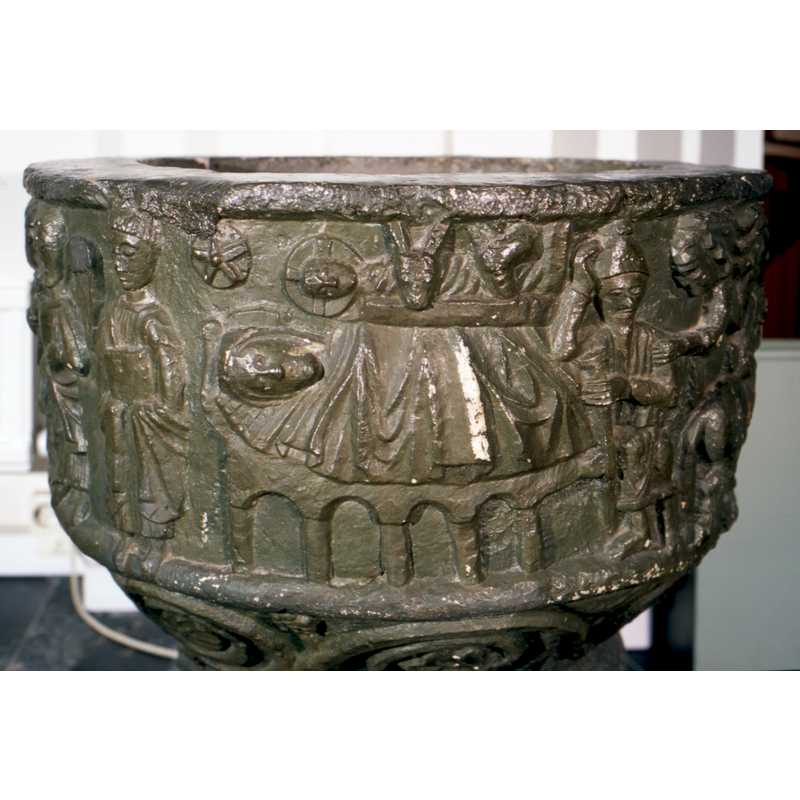 on the north and northwest side of the basin -- Mary lying supine in the bed covered to her neck; no halo; bed has arcade support -- Christ Child wearing cruciferous halo; on a shelf, rather than a manger; heads of the animals cover most of his body -- Joseph seated to the right of the scene, holding his head with the right hand, a staff in his right; an angel flying in on the upper right touches Joseph's shoulder with his hand -- five-point star to the left of Christ's head