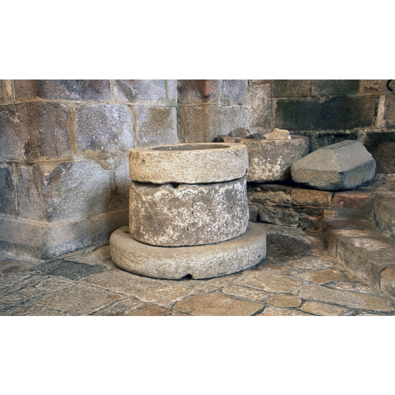 semi-hidden behind the well-head that occupies the foreground of the image is the basin of an ancient font