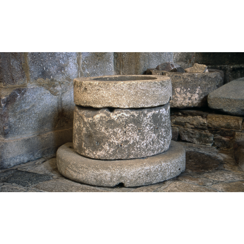 The plinth (?) of the ancient font remains in place inside the church, at the west end, south side -- the object that stands covering part of it is an old well-head from the abbey.