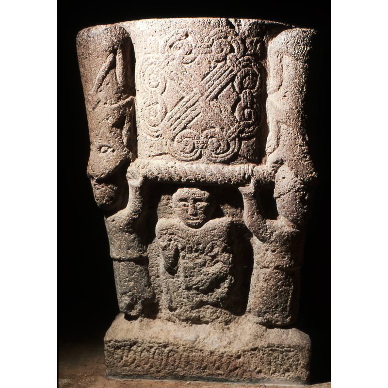 south-east corner: one of four figures supporting the bowl. Crouching animal above the figure devouring the head - like a mask or helmet? -- Photographed in July 1998