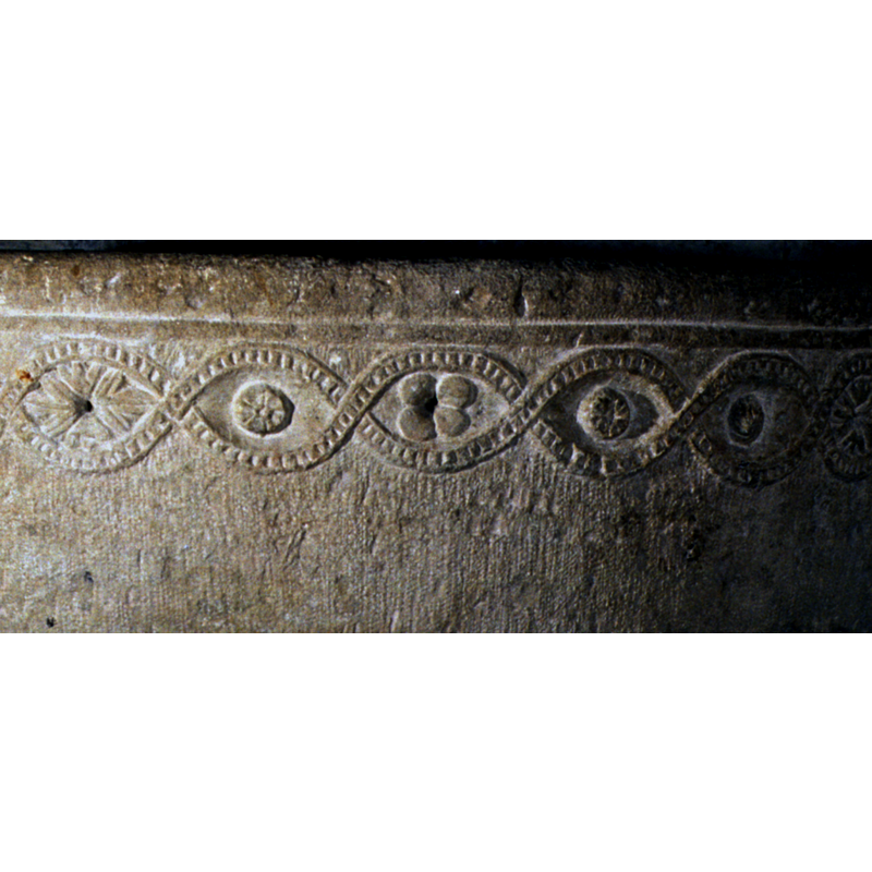 with small floral and foliage motifs inscribed in the loops of the interlace