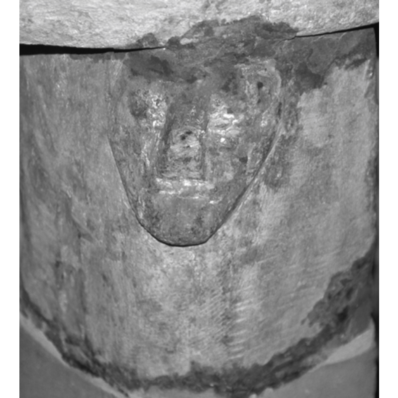 Four very crude human heads, one on each of the columns