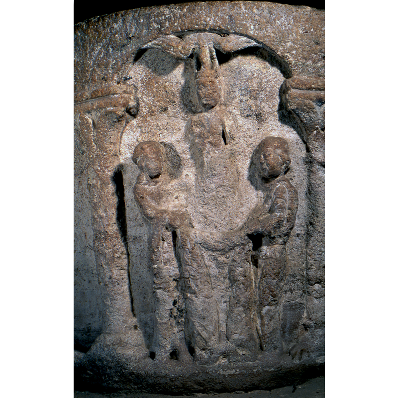 Woman (?) on the left (Mary?) and man on the far right; between them stands Christ, crowned with a dove above him